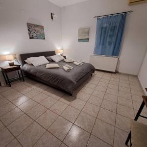 a bedroom with a bed and a tiled floor at Countryhouse with Garden in Vayioniá