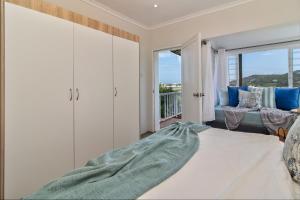 a living room with a bed and a balcony at Lower Deck in Kenton on Sea +16 photos