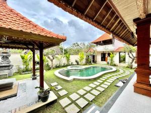 a backyard with a swimming pool and a house at Puri Samana Villas by Tanya Pink in Uluwatu