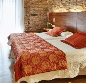 a bedroom with two beds and a stone wall at Mapoula PR Boutique in Santiago de Compostela