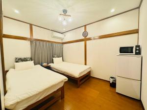 una piccola stanza con due letti e una tv di Oji House-KI0022 a Tokyo