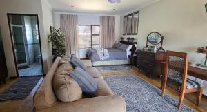 a living room with a couch and a bed at Upstairs R-1 Self-Catering Unit in White River