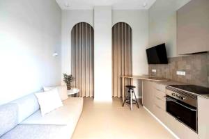 a living room with a couch and a kitchen at Valencia Malvarrosa point beige in Valencia +13 photos