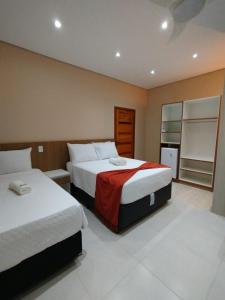 a hotel room with two beds and a refrigerator at Pousada Litoral Paraty in Paraty +174 photos