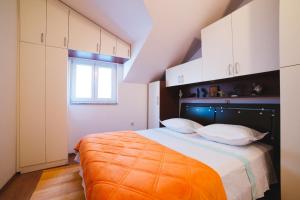 a bedroom with a large bed with white cabinets at Apartment Aldo in Omiš