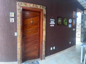 a wooden door in a room with a wall at Casa da Pri in Rio das Ostras
