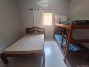 a small room with a bed and bunk beds at Canto Verde Aptos II in Caraguatatuba +85 photos