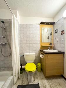 a bathroom with a yellow toilet and a sink at 5- Brides-les-Bains Studio de charme avec vue montagne in Brides-les-Bains