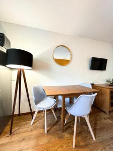 a dining room with a table and two chairs and a mirror at 5- Brides-les-Bains Studio de charme avec vue montagne in Brides-les-Bains