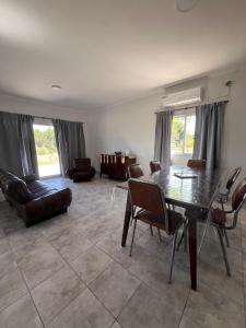 una sala de estar con una mesa y sillas en La Morenita, en Colonia Hughes