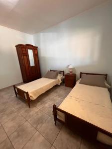 Una habitación con dos camas y una lámpara sobre una mesa. en La Morenita, en Colonia Hughes