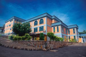 a brick building with a stone wall in front of it at Centre Missionnaire Lavigerie in Kigali