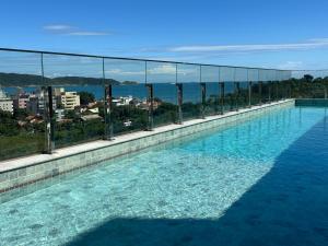 a swimming pool with a view of the water at Apto com piscina aquecida perto do mar in Bombinhas
