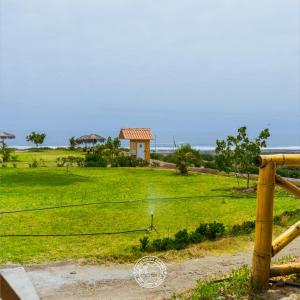a view of a field with a house in the background at Hotel Puerta Grande Mollendo Mejia in Mollendo