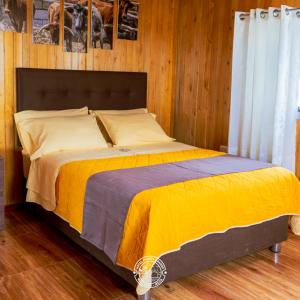 a bedroom with a bed with a yellow blanket at Hotel Puerta Grande Mollendo Mejia in Mollendo