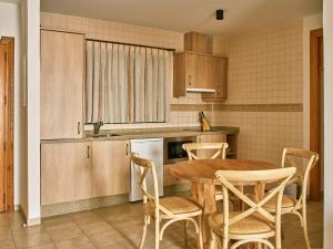 a kitchen with a wooden table and chairs at Apartamentos Turísticos Casa de La Borrega in Estepona