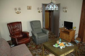 a living room with a couch chair and a television at Gasthof Holländer Eck in Lennestadt