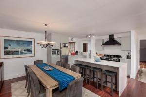 a kitchen and dining room with a table and chairs at Die Rietdak - Reetdachhaus mit vier Schlafzimmern in Cape Town