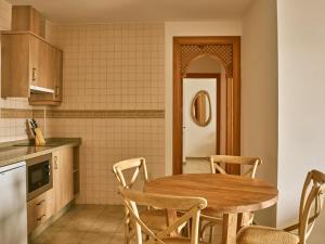 a kitchen with a wooden table and chairs at Apartamentos Turísticos Casa de La Borrega in Estepona