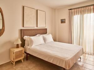 a bedroom with a bed with white sheets and a window at Apartamentos Turísticos Casa de La Borrega in Estepona