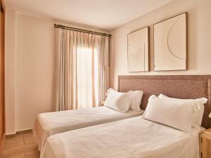 two beds sitting next to each other in a room at Apartamentos Turísticos Casa de La Borrega in Estepona