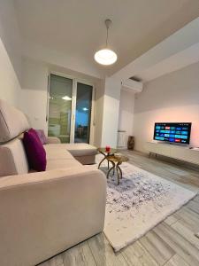 a living room with a couch and a tv at Mor Maison Skopje City-Center FEW FREE PRIVATE PARKING in Skopje