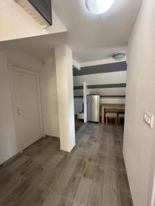 an empty room with a refrigerator and a table at Apartman Rim  +7 photos