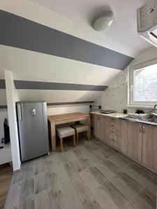 a kitchen with a refrigerator and a table in it at Apartman Rim 