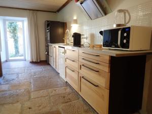 a kitchen with a counter top with a microwave at Gîte le creux de vennes in Guyans-Vennes