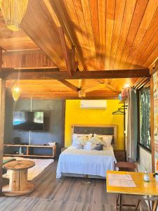a bedroom with a bed and a wooden ceiling at Chalé Cabana Lumiar in Nova Friburgo +22 photos