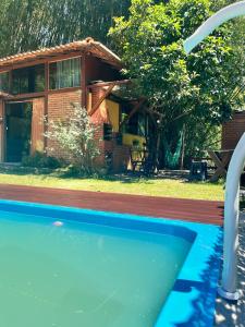a swimming pool in front of a house at Chalé Cabana Lumiar in Nova Friburgo