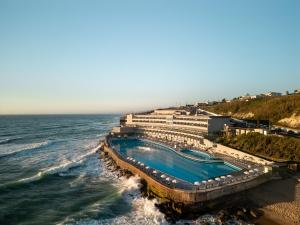 a swimming pool on the beach next to the ocean at Arribas Sintra Hotel in Sintra