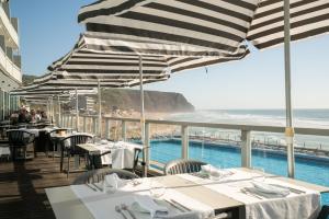 a restaurant with tables and chairs with a view of the ocean at Arribas Sintra Hotel in Sintra