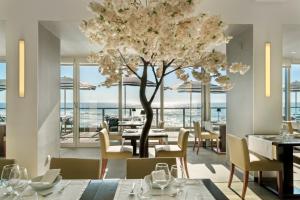 a restaurant with a tree and tables and chairs at Arribas Sintra Hotel in Sintra
