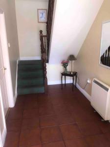 a hallway with a staircase with a green carpet at Fionas Seaside Cottage in Ballybunion