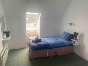 a bedroom with a bed in a room with a window at Fionas Seaside Cottage in Ballybunion