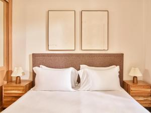 a bedroom with a white bed with two lamps at Apartamentos Turísticos Casa de La Borrega in Estepona