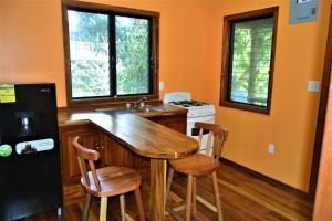 a kitchen with a wooden table and two chairs at Licensed 2 bedroom cabin Close to San Ignacio, local dining, and adventure tours in San Ignacio