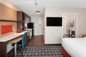 a hotel room with a bed and a desk and a kitchen at TownePlace Suites by Marriott Titusville Kennedy Space Center in Titusville