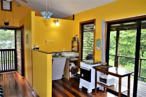 a kitchen with yellow walls and a wooden floor at Treetop Jungle Like Escape in San Ignacio Your Belize Oasis Awaits in San Ignacio +18 photos