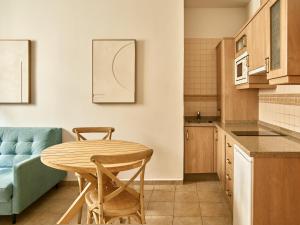 a kitchen with a table and a blue couch at Apartamentos Turísticos Casa de La Borrega in Estepona