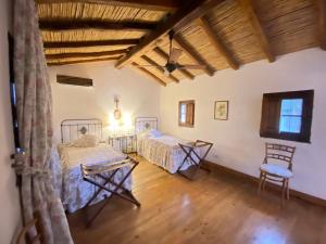 a bedroom with two beds in a room with wooden floors at El Palomar casa de campo in Churqui Cañada +50 photos