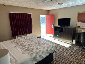 フランクリンにあるAmericas Best Value Inn Franklinのベッドと薄型テレビがあるホテルの部屋