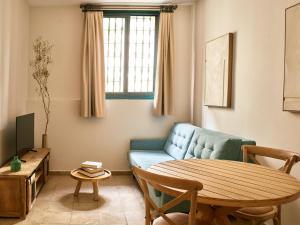 a living room with a blue couch and a table at Apartamentos Turísticos Casa de La Borrega in Estepona