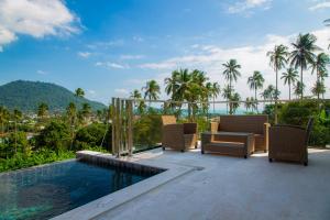 a patio with chairs and a pool and palm trees at Scenic Lamai Getaway in Amphoe Koh Samui