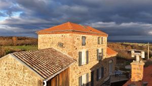 an old brick building with a roof on top of it at Le mas du Pilat in Bessey