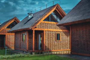 a house with a thatched roof at Domki Kuter Port in Gdów