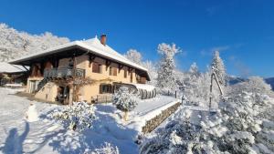 ein schneebedecktes Haus in einem verschneiten Wald in der Unterkunft Le Refuge du Montagnard in Marthod