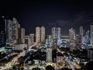 una ciudad iluminada por la noche con edificios altos en The Gray by Wynwood House, en Panamá