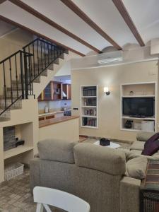 Una sala de estar con un sofá y una escalera. en Les Dos Nines, en Monserrat